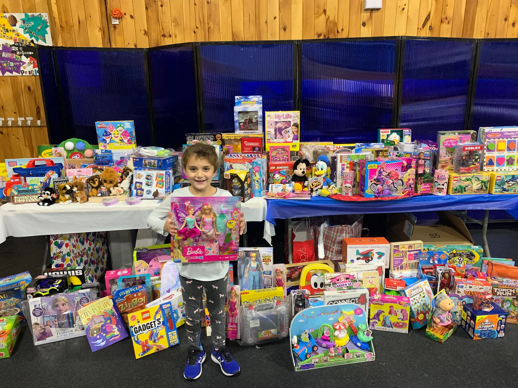 A child with toys collected by the Driftwood community