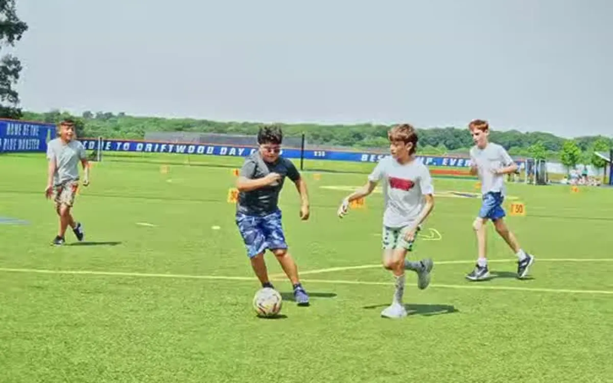 Driftwood pre-teen campers playing soccer together on the turf field